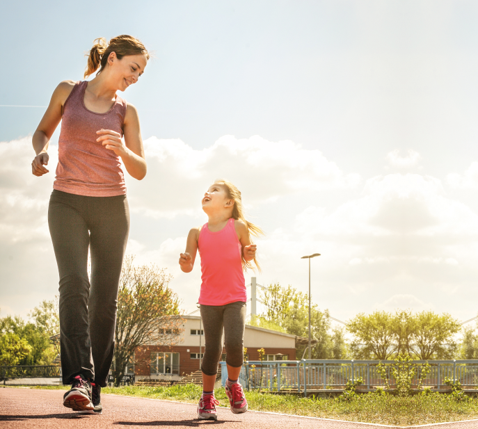 Mutter mit ihrer kleinen Tochter beim Jogging an einem sonnigen Tag. 