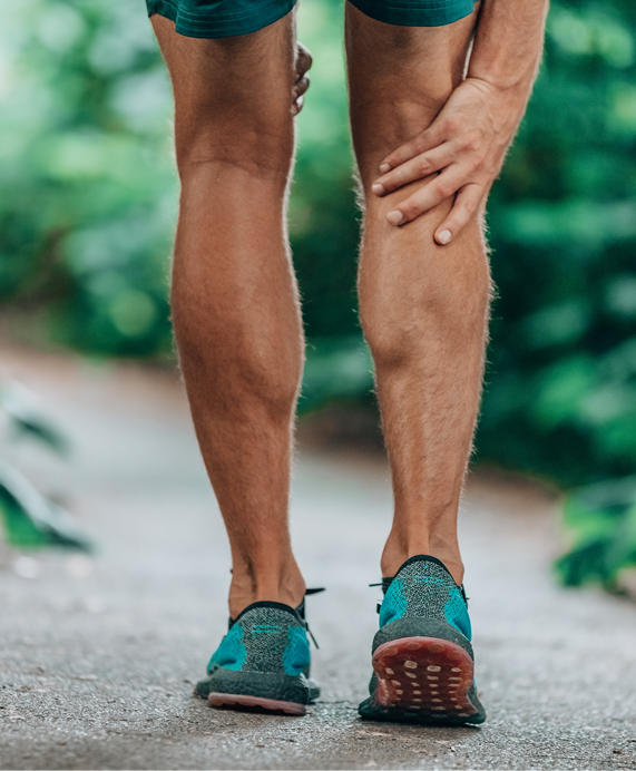 Sportler hat beim Joggen einen unangenehmen Wadenkrampf